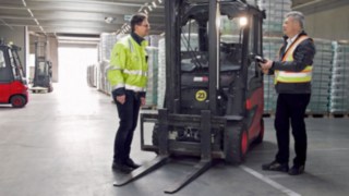 Dvaja zamestnanci zo spoločnosti CTL stoja vedľa čelného elektrického vozíka E30 od spoločnosti Linde Material Handling.